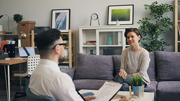 Woman talking with a therapist during a counseling session in a comfortable office setting.