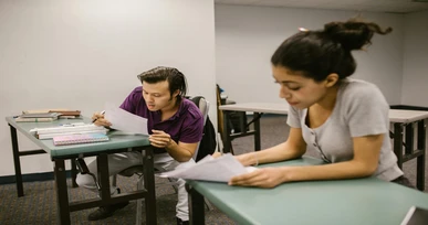 students solving exam papers in classroom with online exam help support